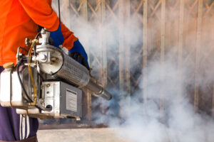 A man use fumigation mosquitoes machine for kill mosquito carrier of Zika virus and dengue fever prevention outbreak in school at the rainy season.Soft and blur focus.