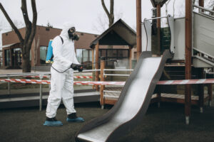 Cleaning and Disinfection on the playground in the sity complex amid the coronavirus epidemic Professional teams for disinfection efforts Infection prevention and control of epidemic Protective suit and mask and spray bag,