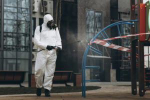 Cleaning and Disinfection on the playground in the sity complex amid the coronavirus epidemic Professional teams for disinfection efforts Infection prevention and control of epidemic Protective suit and mask and spray bag,