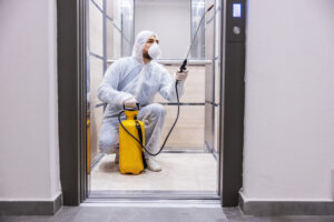 Sanitizing interior surfaces. Cleaning and Disinfection inside buildings, the coronavirus epidemic. Professional teams for disinfection efforts. Infection prevention and control of epidemic. Protective suit and mask.