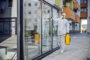 Cleaning and Disinfection outside around buildings, the coronavirus epidemic. Professional teams for disinfection efforts. Infection prevention and control of epidemic. Protective suit and mask. Professional specialist full protective cleaning outside.