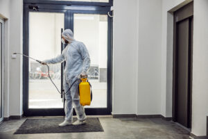 Sanitizing interior surfaces. Cleaning and Disinfection inside buildings, the coronavirus epidemic. Professional teams for disinfection efforts. Infection prevention and control of epidemic. Protective suit and mask.